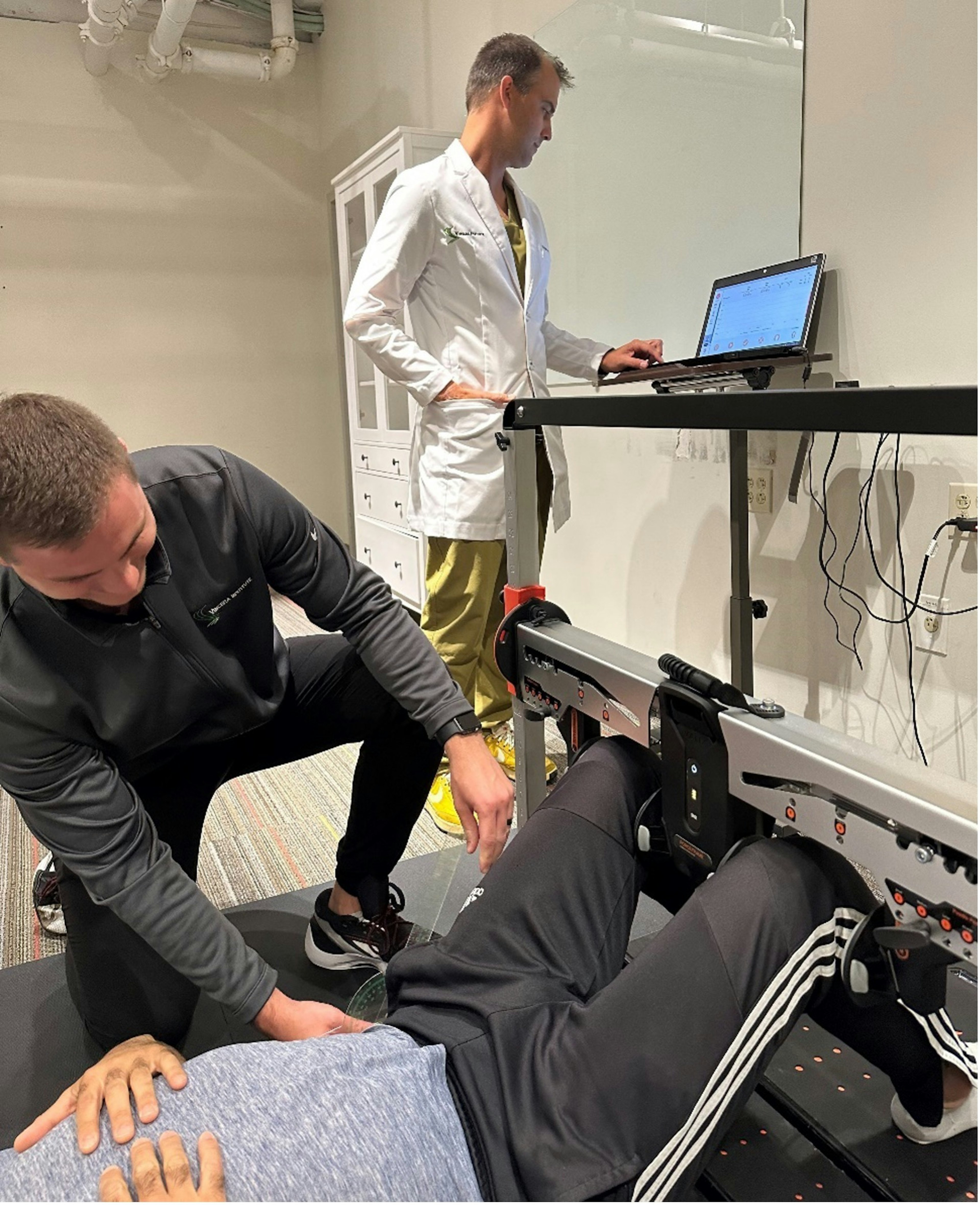 Dr. Poor (right) and Clark Bingol (left; athletic trainer) conducting abduction : adduction testing on ForceFrame.